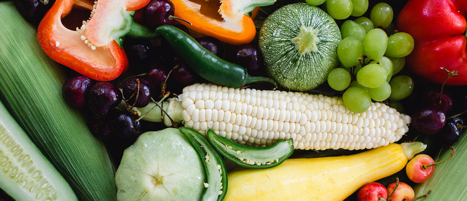 vegetables and fruits gathered in a pile and shot from overhead.