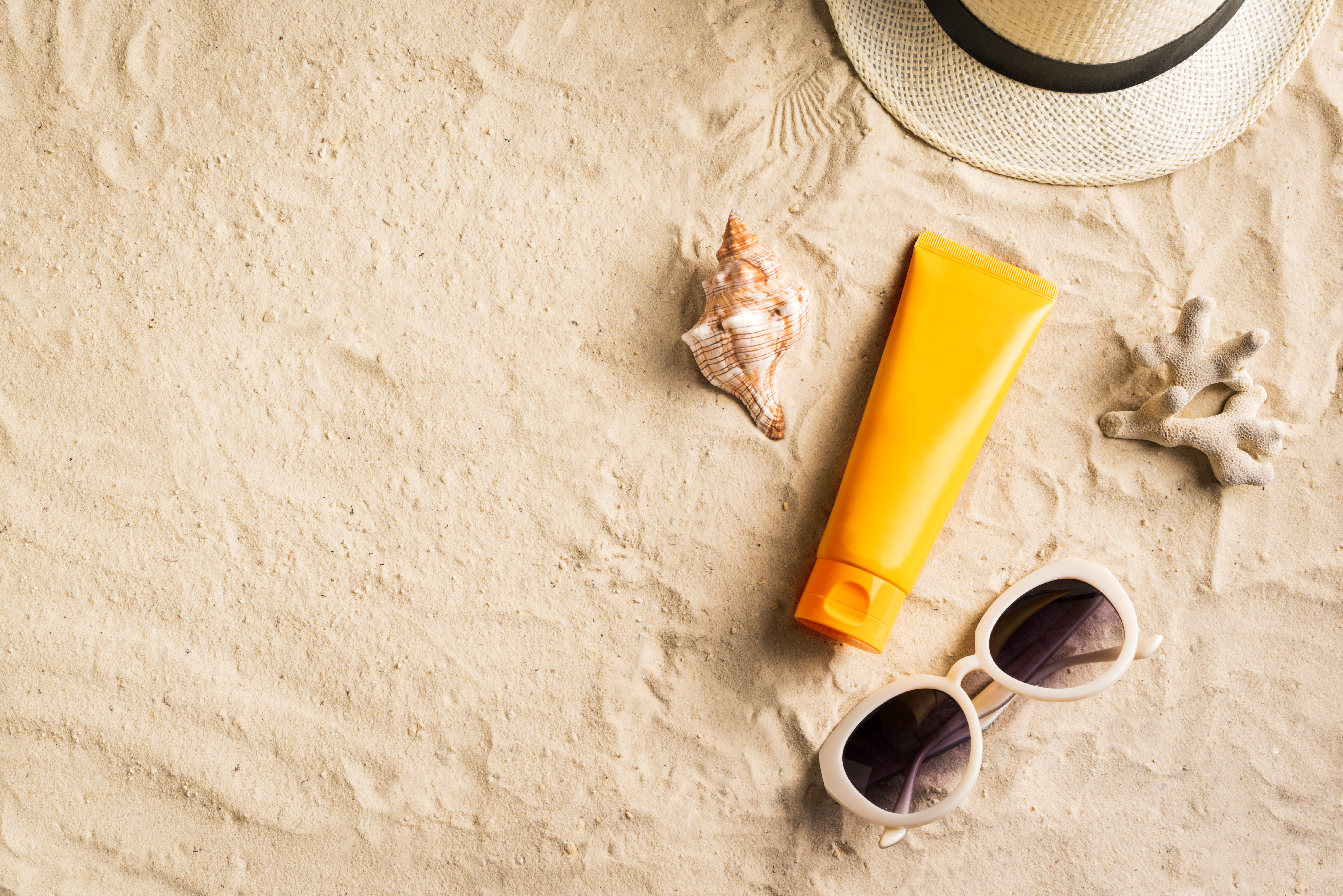 beach with sunscreen sunglasses and hat