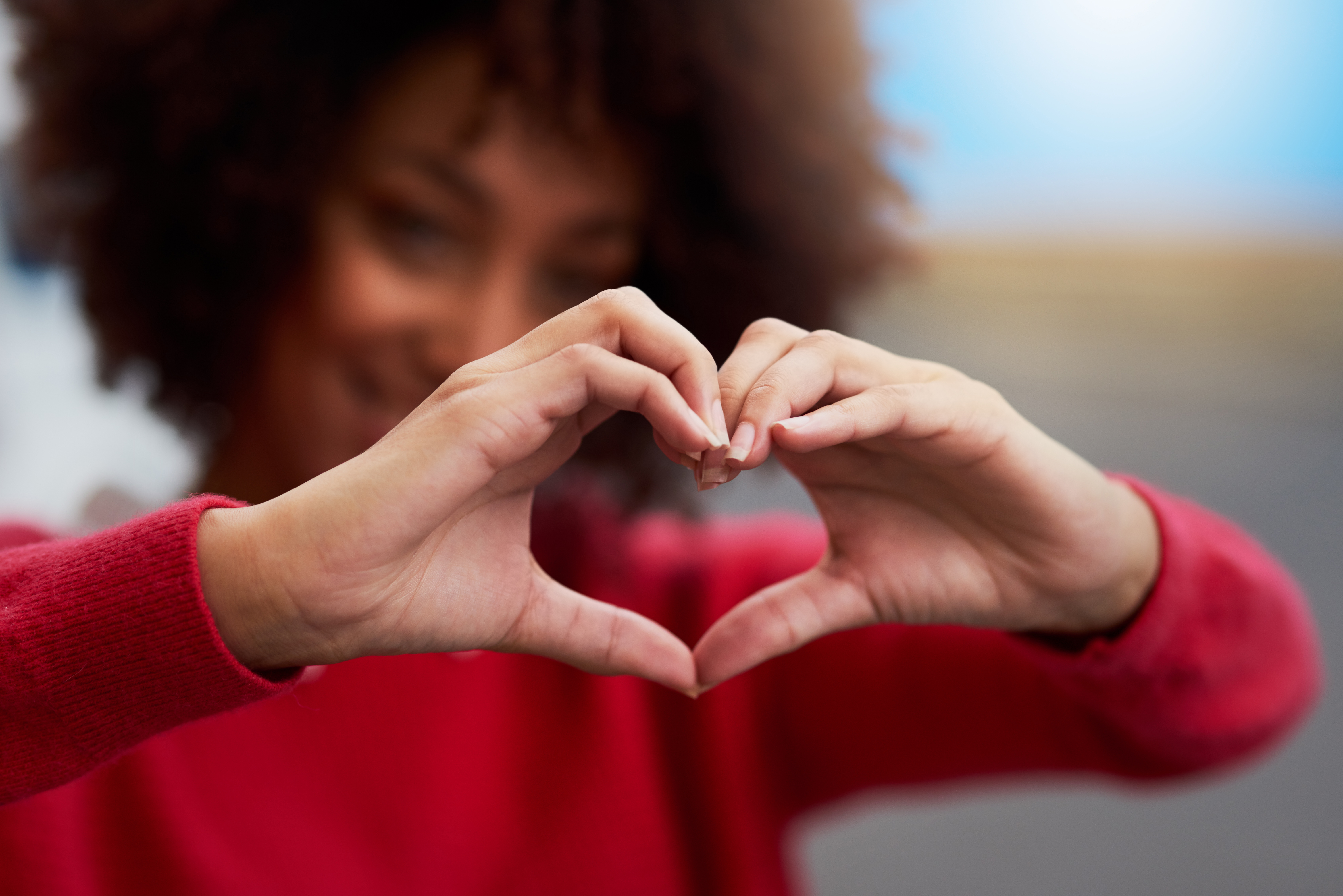 woman forming a heart with her hands