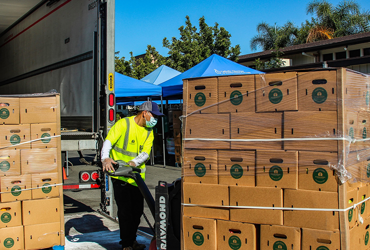 a man moving boxes at Coastside Hope 